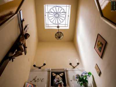 Alla sua sinistra � appeso alla parete un ottocentesco crocifisso in legno, illuminato dai raggi del sole che filtrano timidamente da un secondo lucernario
